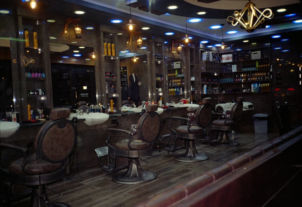 The shop — leather chairs, mirrored stations, warm pendant light